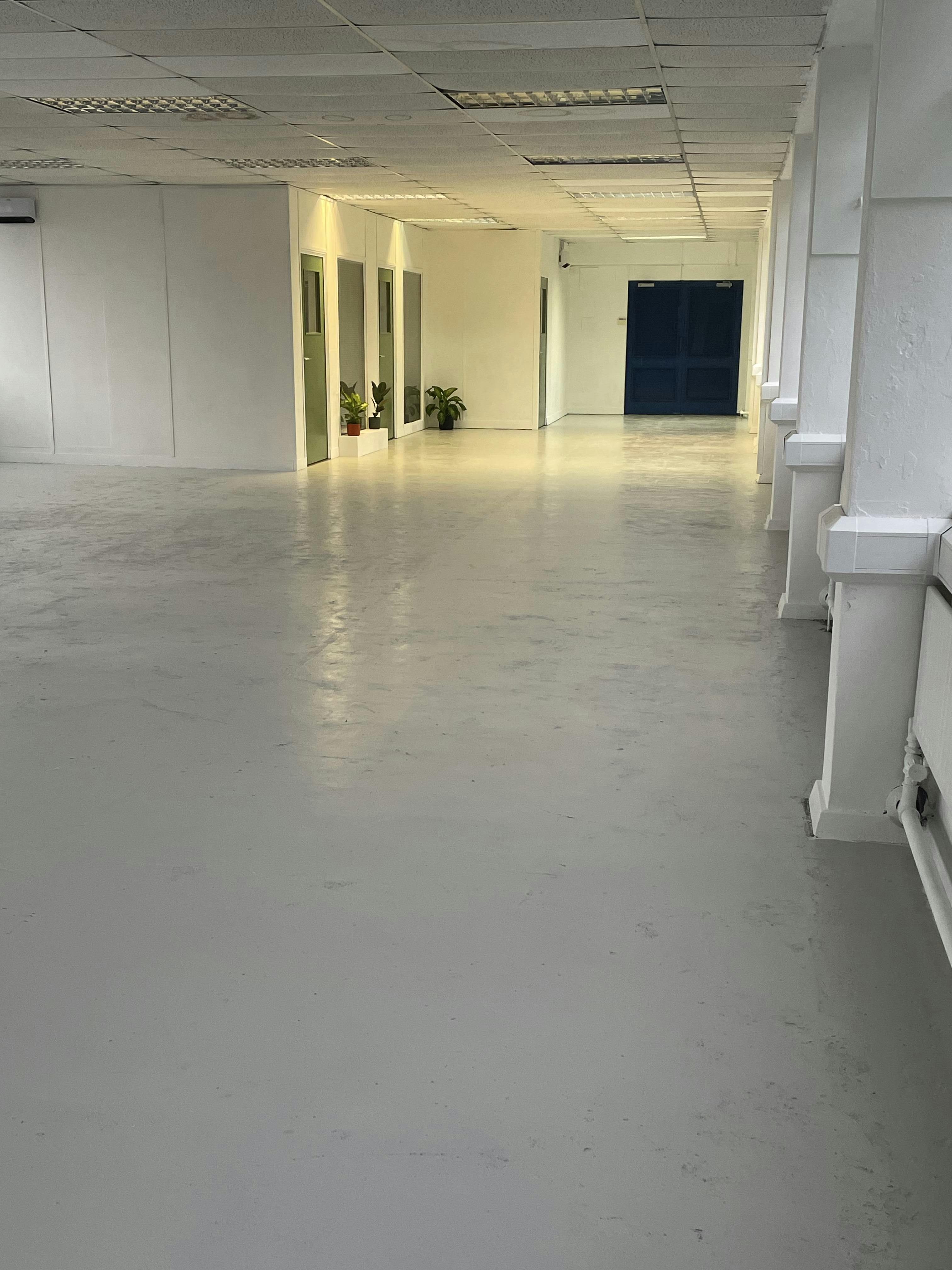 Spacious pink gallery corridor with polished floor for events and networking.