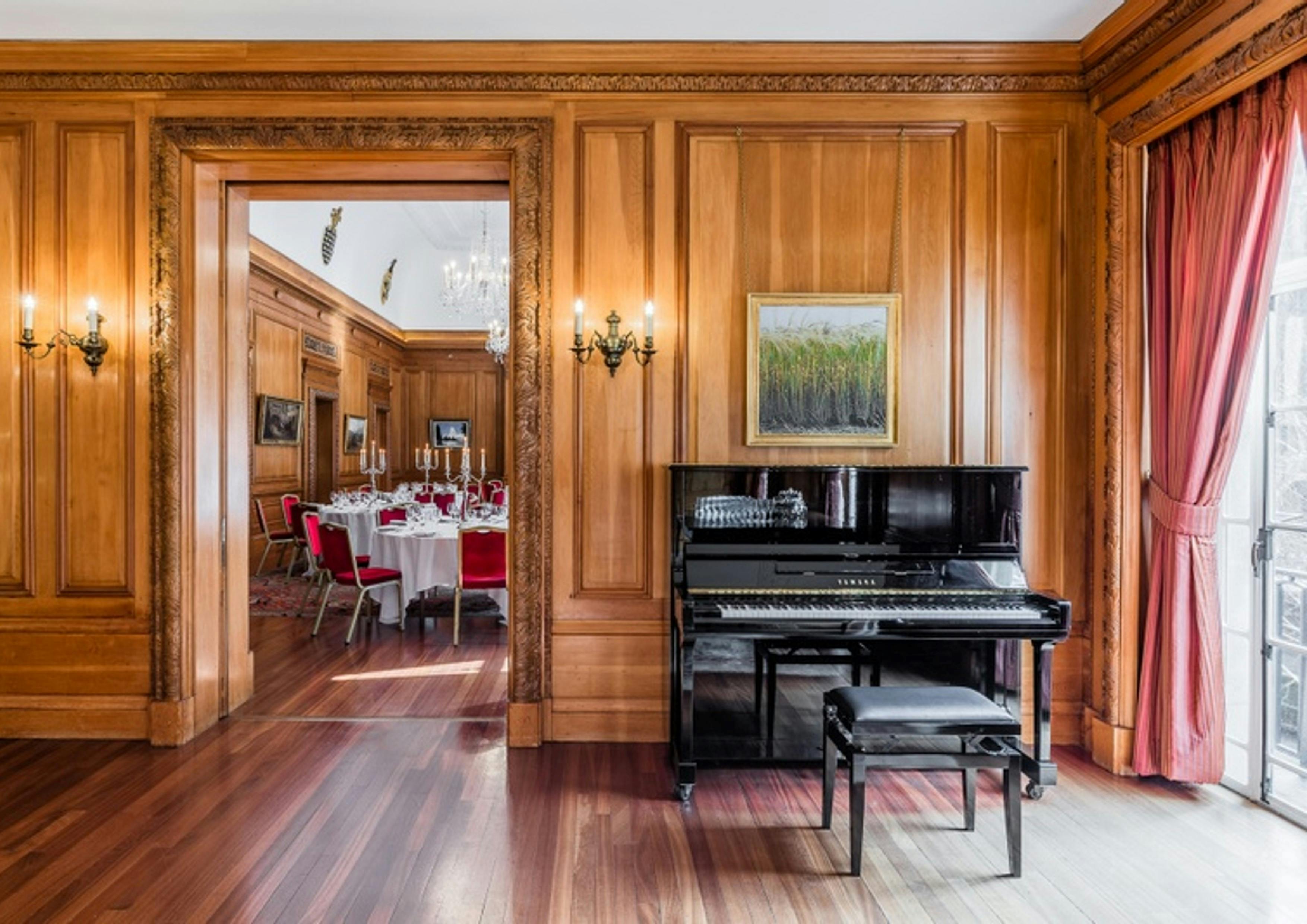 Elegant Christmas event at Brewers' Hall with grand piano and red-accented tables.