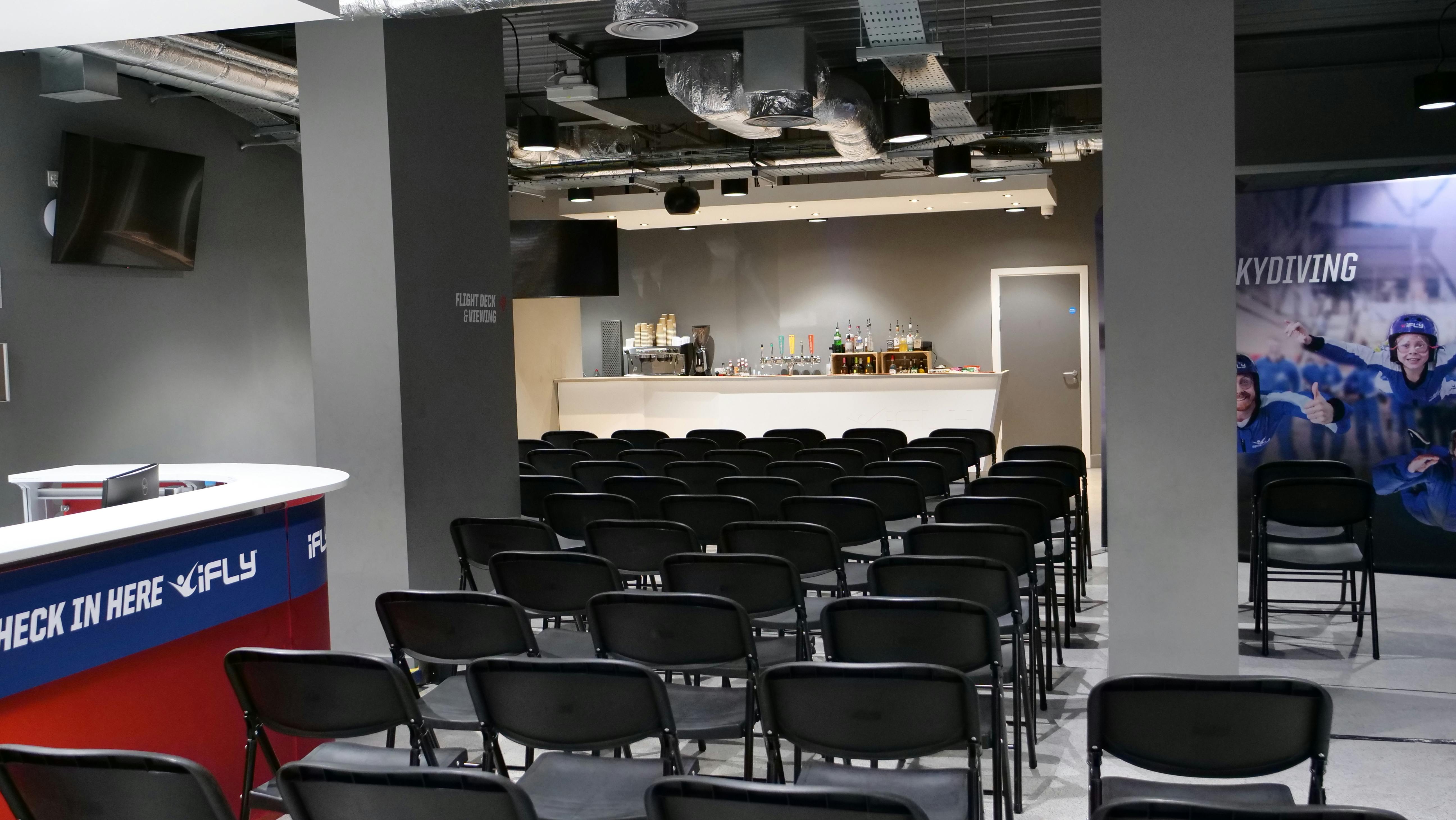 iFLY Indoor Skydiving bar event space with black chairs for meetings and gatherings