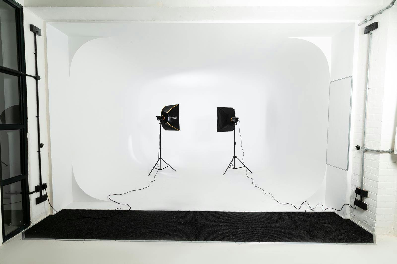 Minimalist photography studio with seamless white backdrop for branding events.