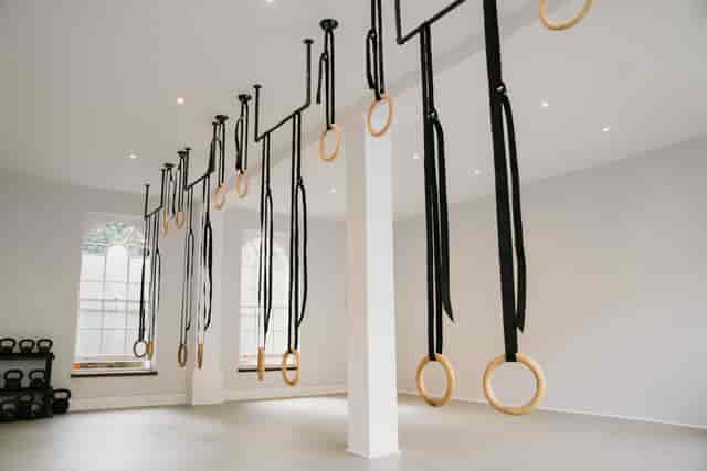 Modern fitness studio with gymnastic rings, ideal for wellness events and group workouts.