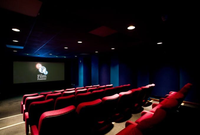 Intimate screening room with plush red seating for private film events and presentations.