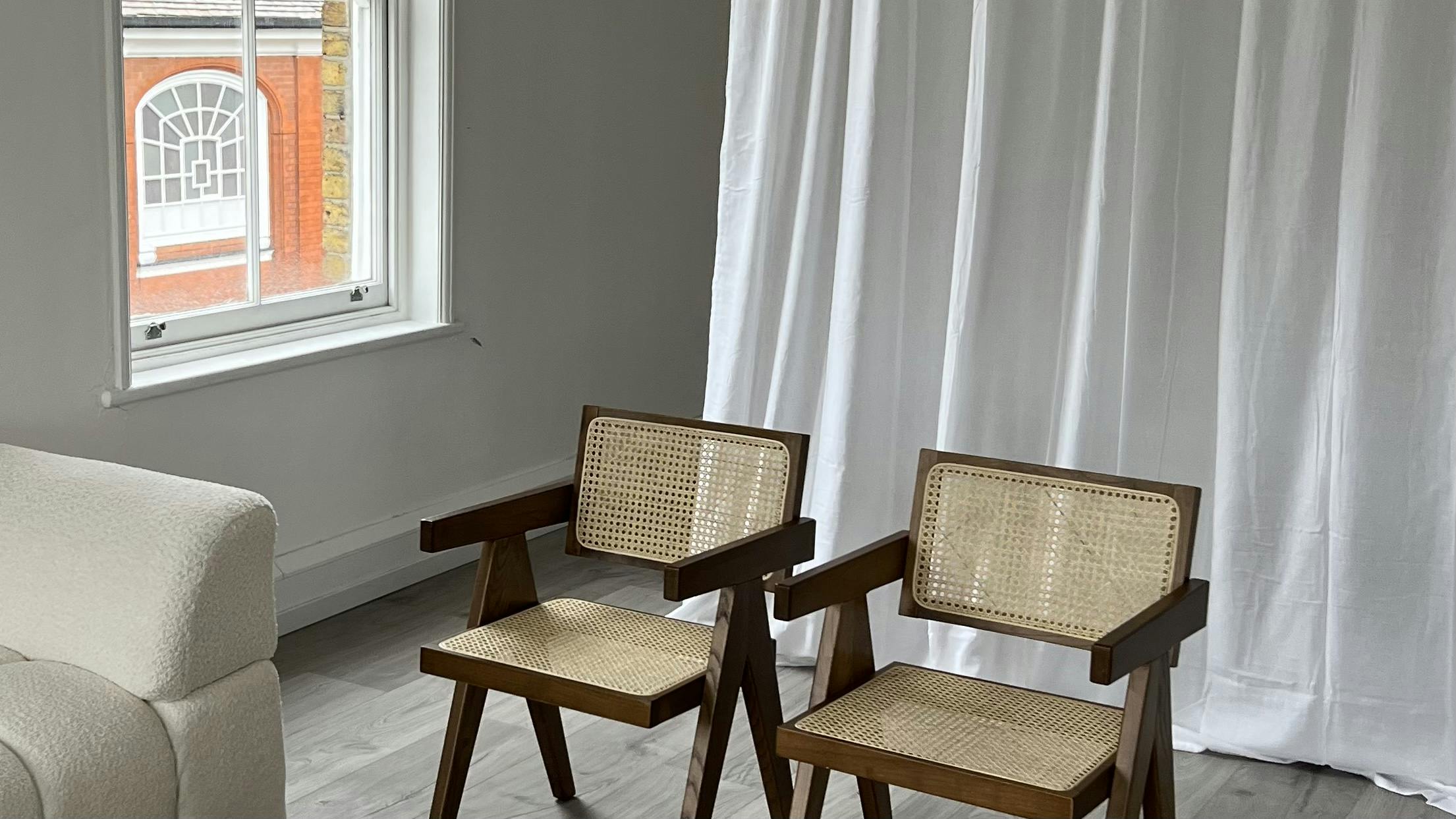 Minimalist meeting space with wooden chairs and natural light for intimate gatherings.