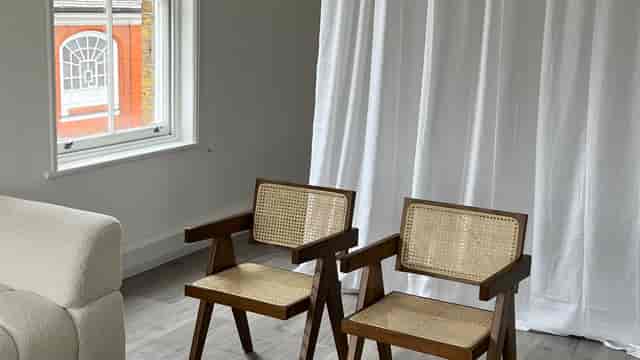 Minimalist meeting space with wooden chairs and natural light for intimate gatherings.