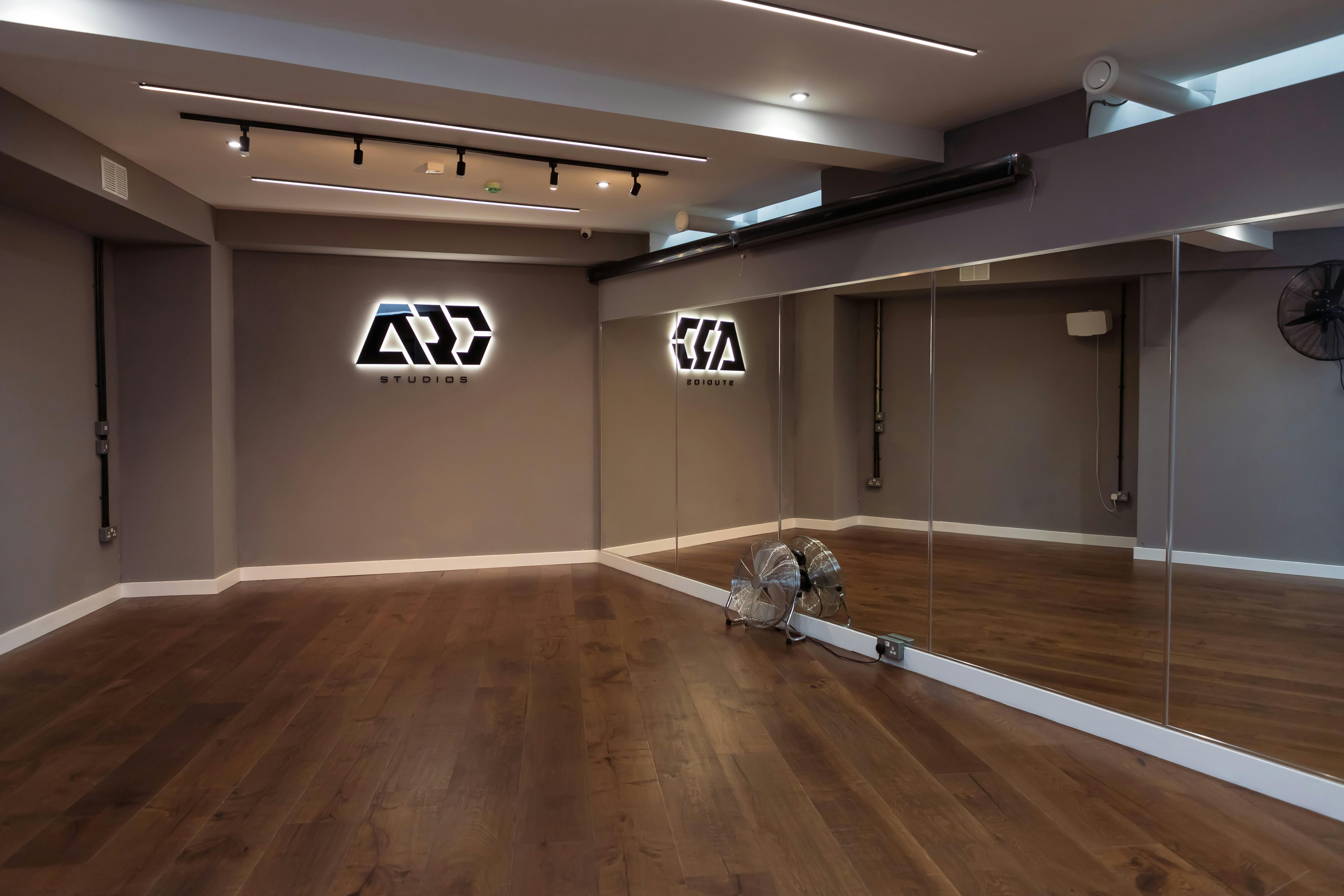 Versatile event space with mirrored walls, ideal for workshops and fitness classes.