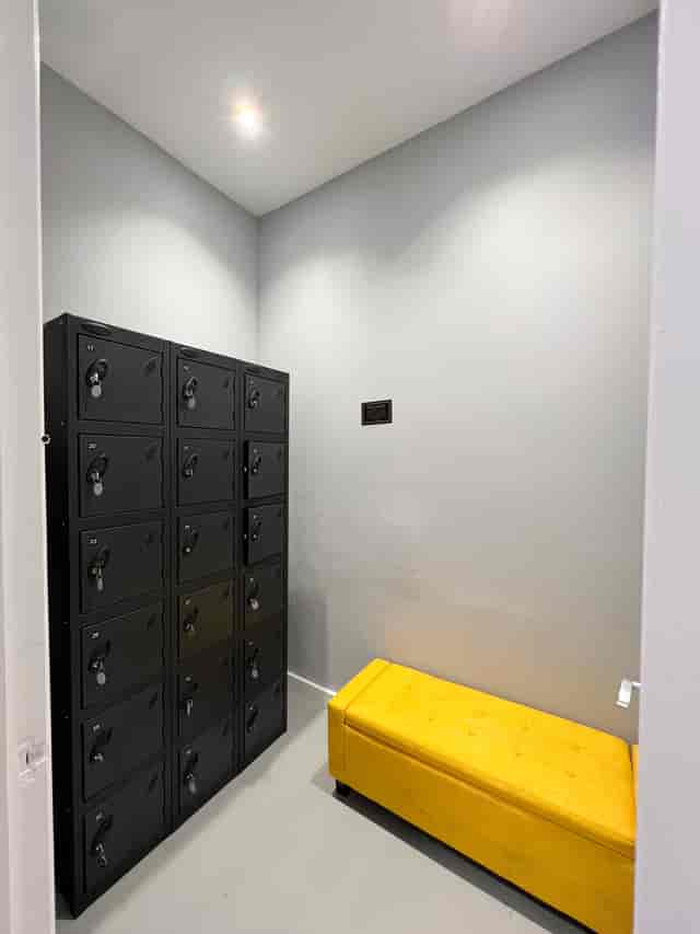 Compact storage area with black lockers and yellow bench for events at ARC STUDIOS.