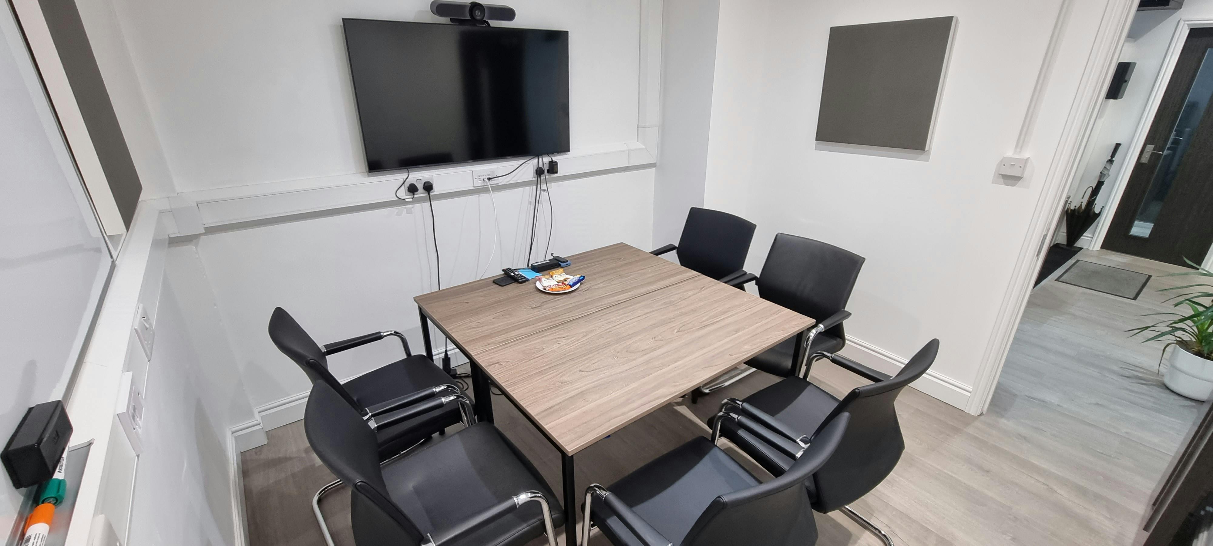 Modern meeting room with sleek table and ergonomic chairs for productive collaboration.