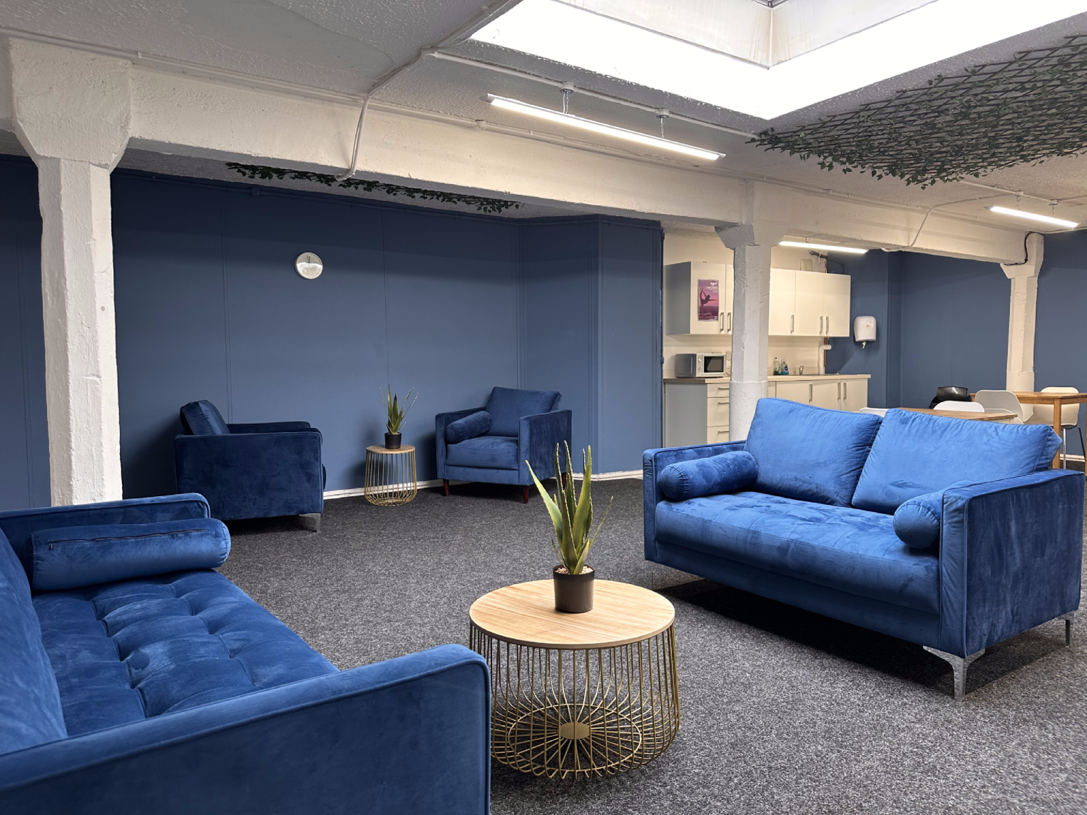 Modern lounge area with blue sofas for informal meetings in Glasgow Training Rooms.