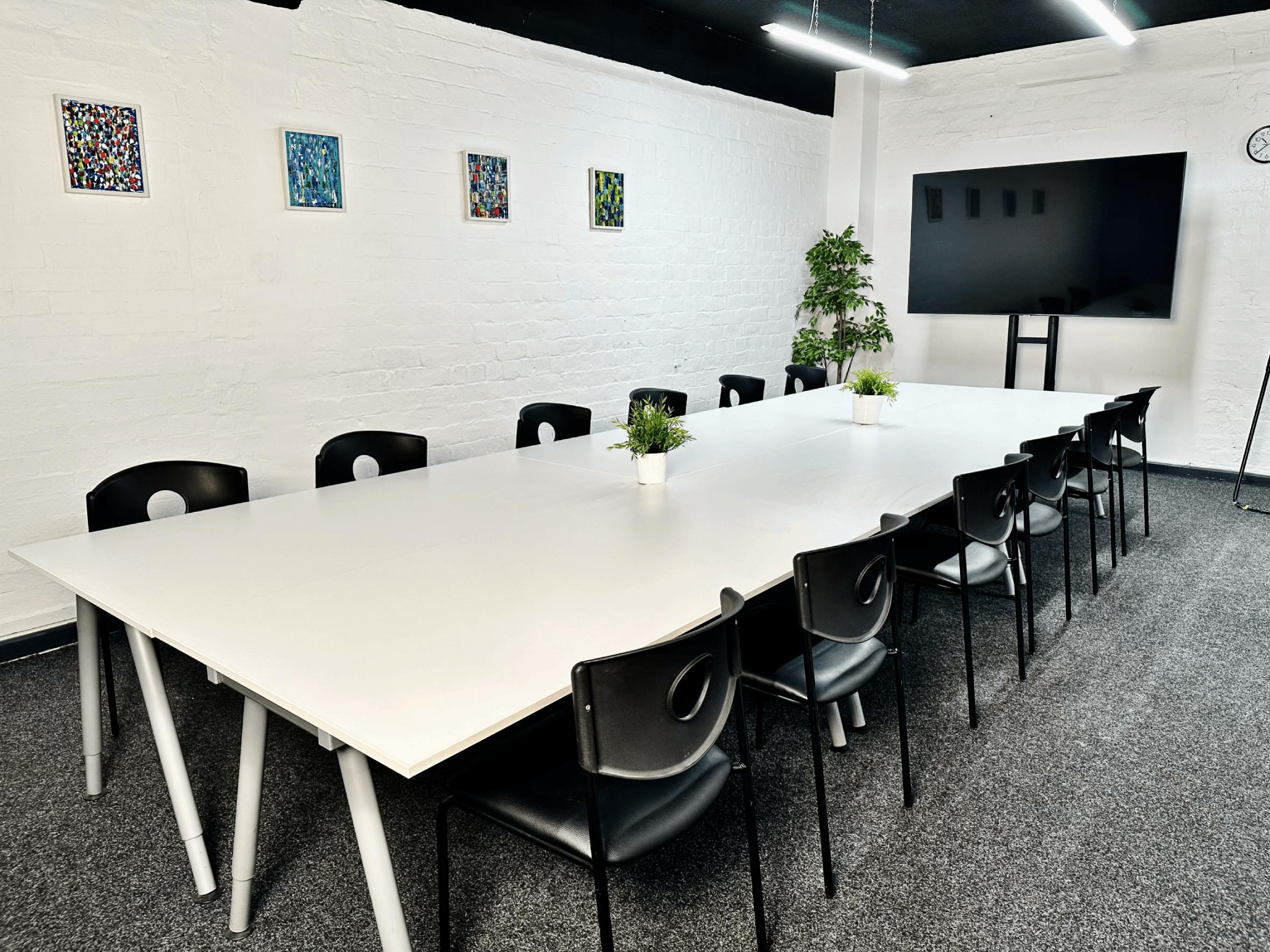 Modern meeting room in Glasgow with white table, ideal for collaborative events.