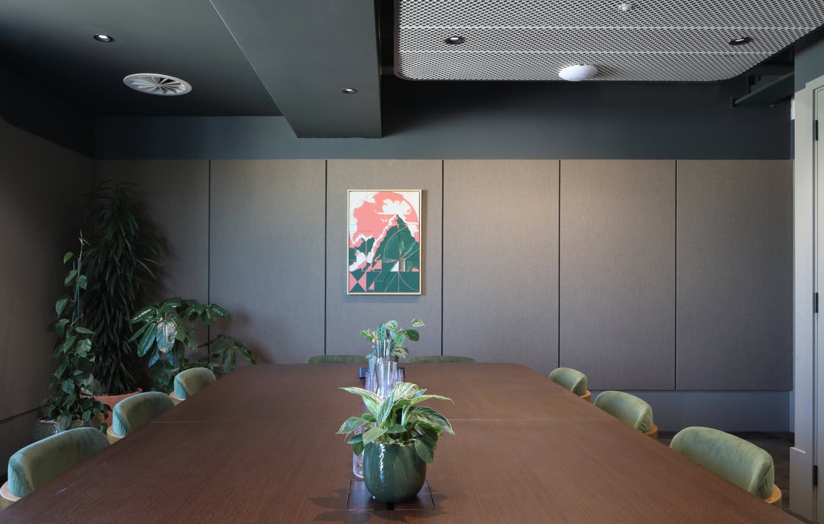 Modern meeting room with wooden table, greenery for collaborative brainstorming sessions.