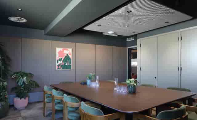 Modern meeting room with wooden table, ideal for collaborative brainstorming sessions.
