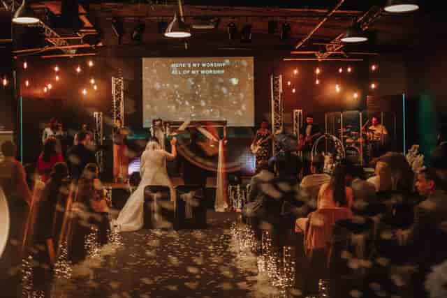 Wedding reception in elegant function hall with band and festive confetti.