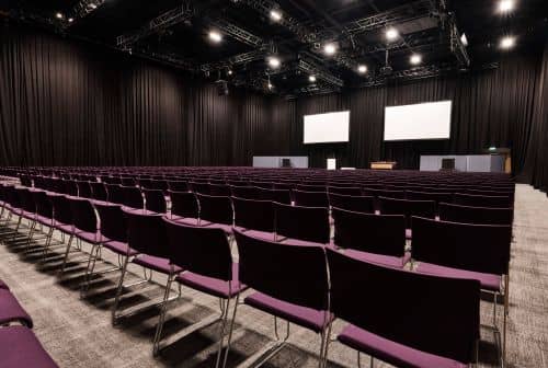 ICC Belfast conference venue with empty chairs and stage, perfect for presentations and workshops.