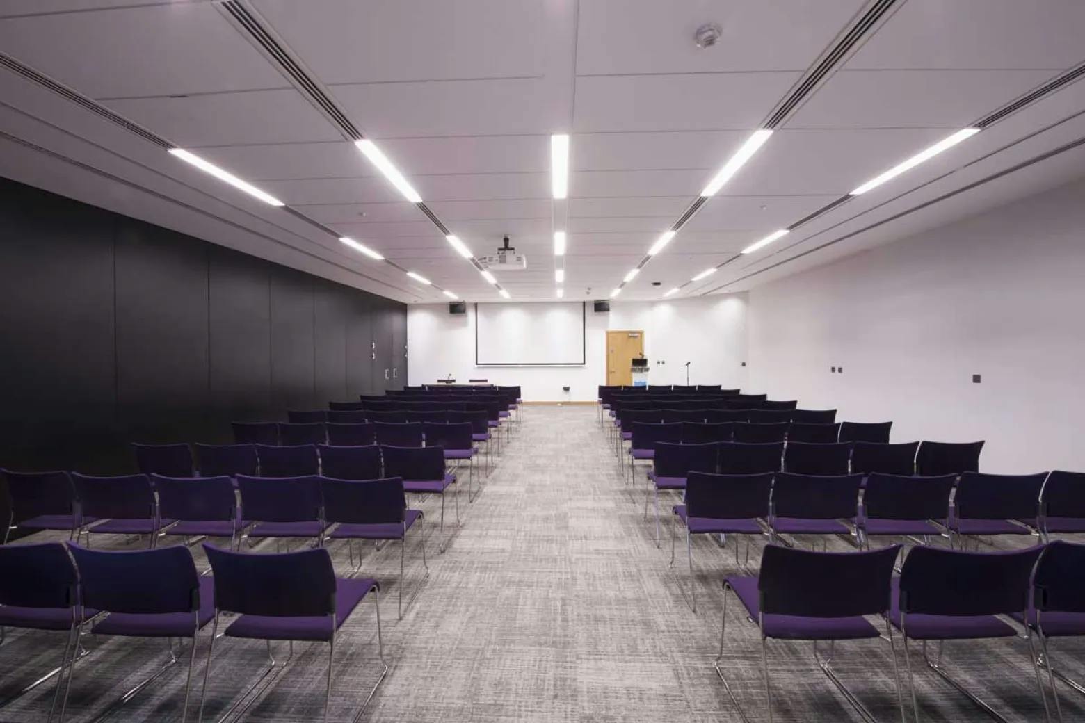 Modern event space in ICC Belfast with purple chairs, ideal for conferences and workshops.