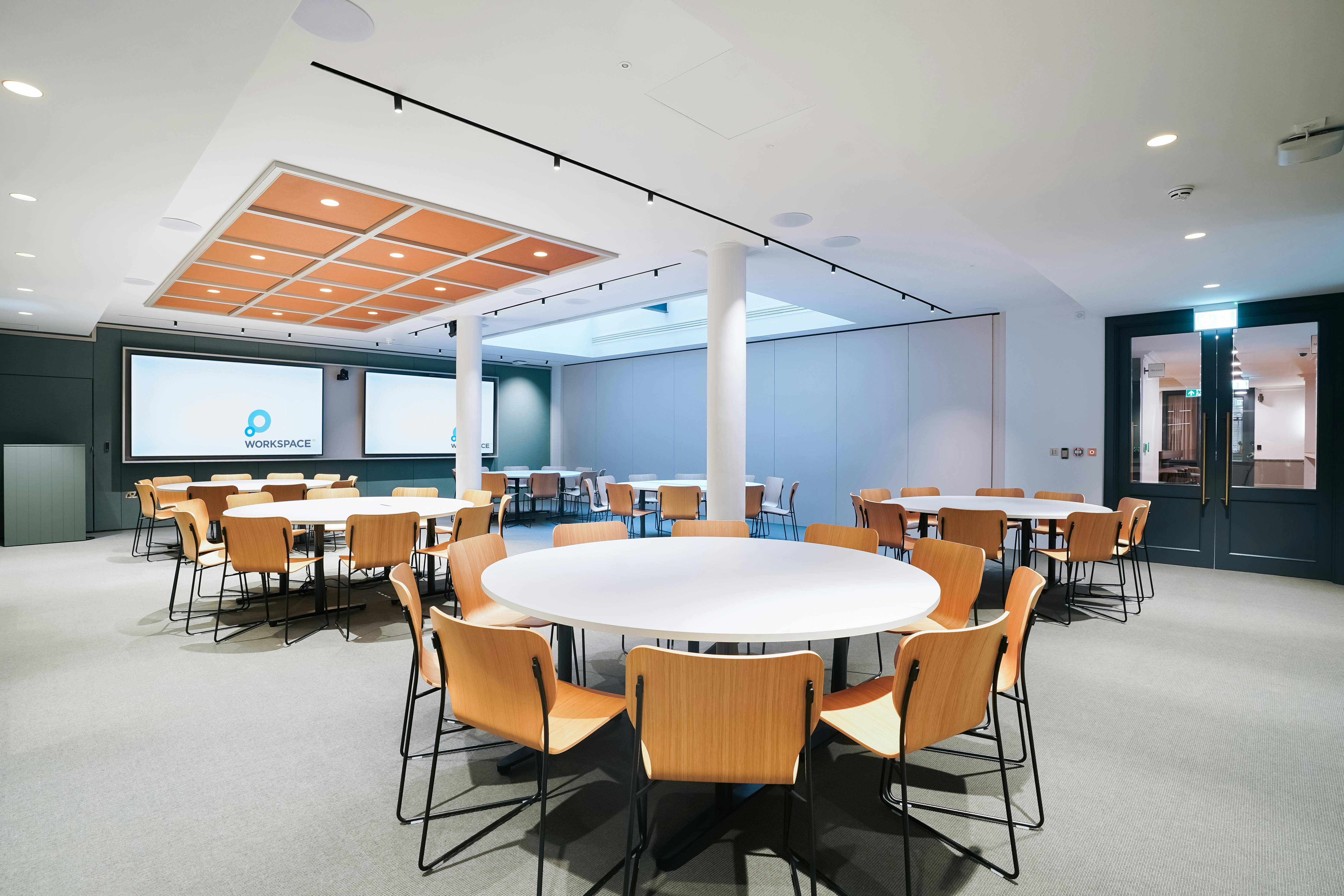 Versatile meeting space at Salisbury House with circular tables for workshops and networking.