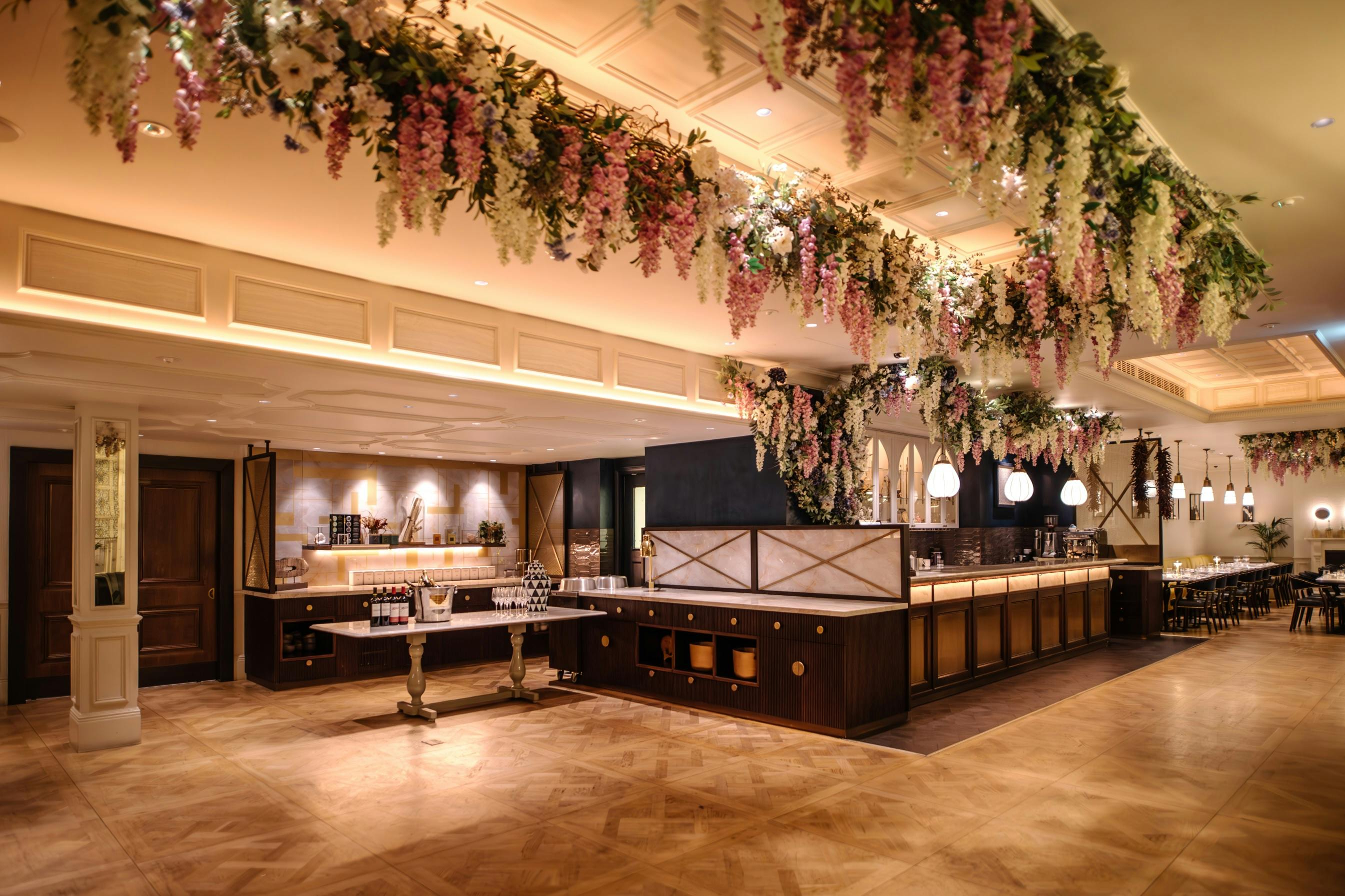 Elegant event space at Cento, 100 Queen's Gate Hotel, with floral decor and bar area.