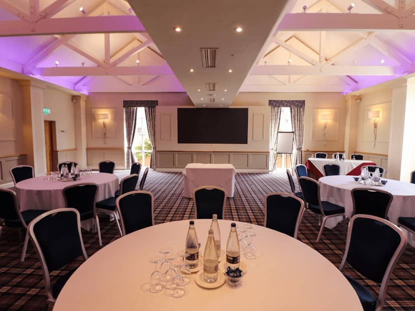 Carden Suite meeting room with round tables, ideal for conferences and workshops.
