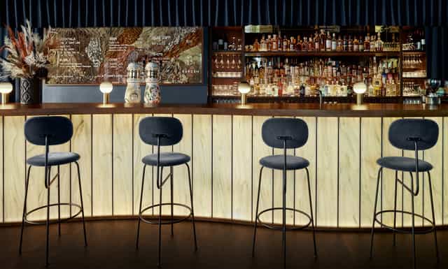 Sleek cocktail bar with stylish stools, ideal for networking events and receptions.