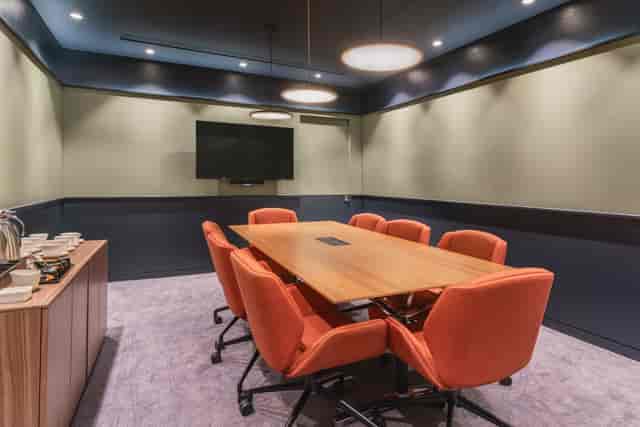 Rooftop bar meeting room with spacious table and orange chairs for corporate events.