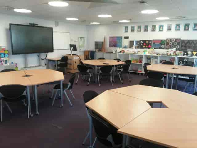 Versatile teaching room with hexagonal tables for STEM workshops and brainstorming sessions.