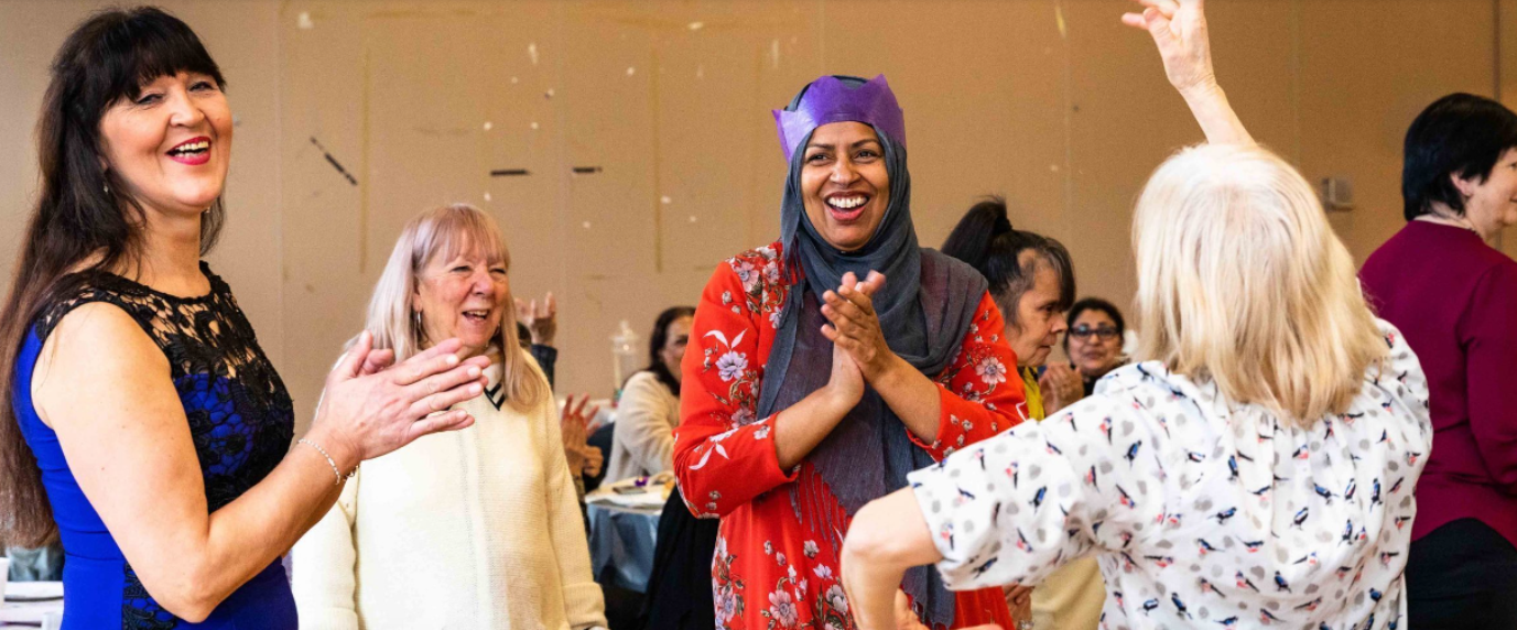 Middleton Hall event with diverse women celebrating in colorful attire. - Banner