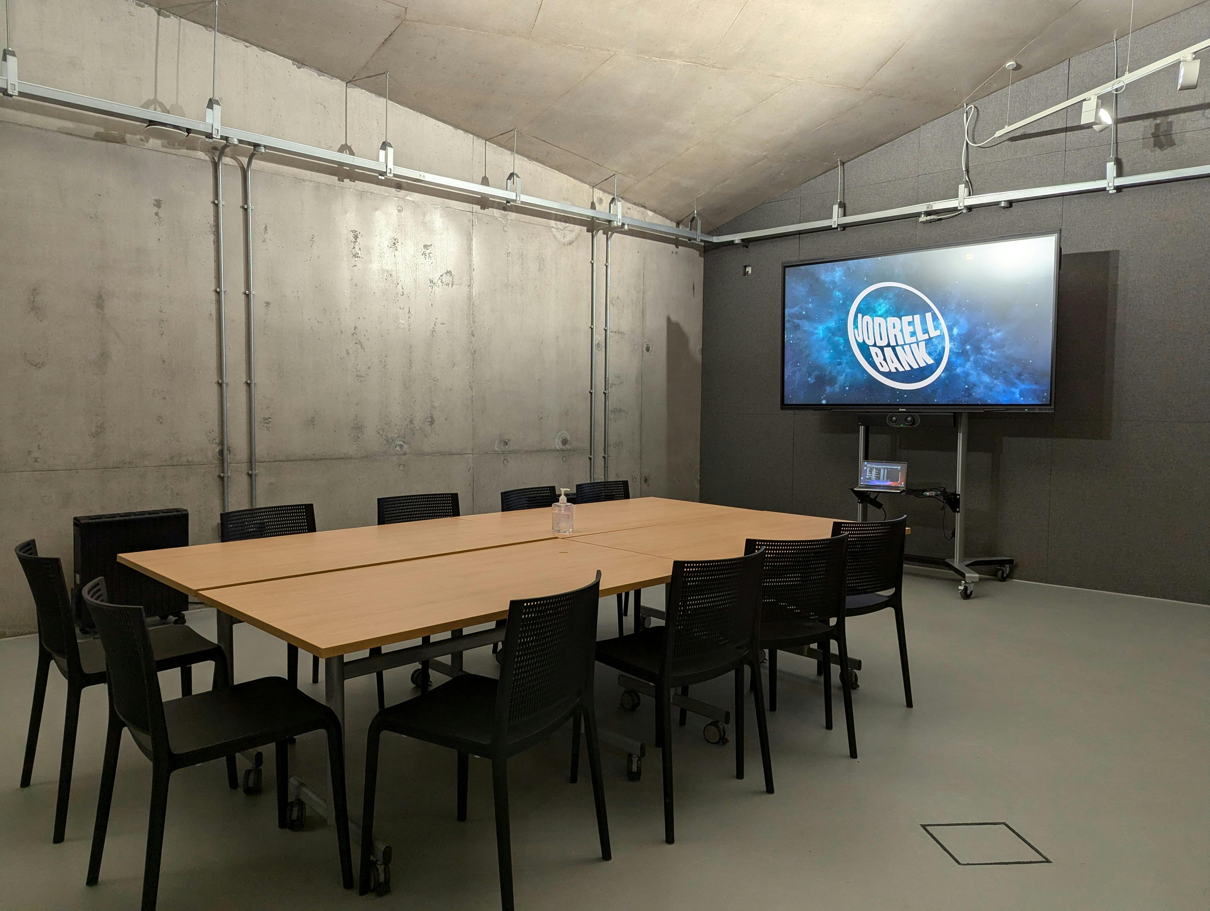 Modern meeting room at Jodrell Bank with large table, ideal for presentations and collaboration.