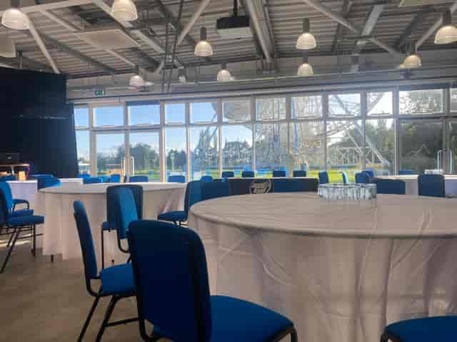 Wolfson Auditorium event space with round tables and blue chairs, ideal for meetings.