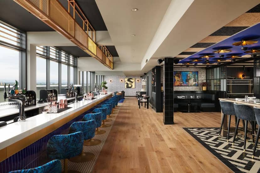Modern event space in Malmaison York with vibrant blue seating and natural light.