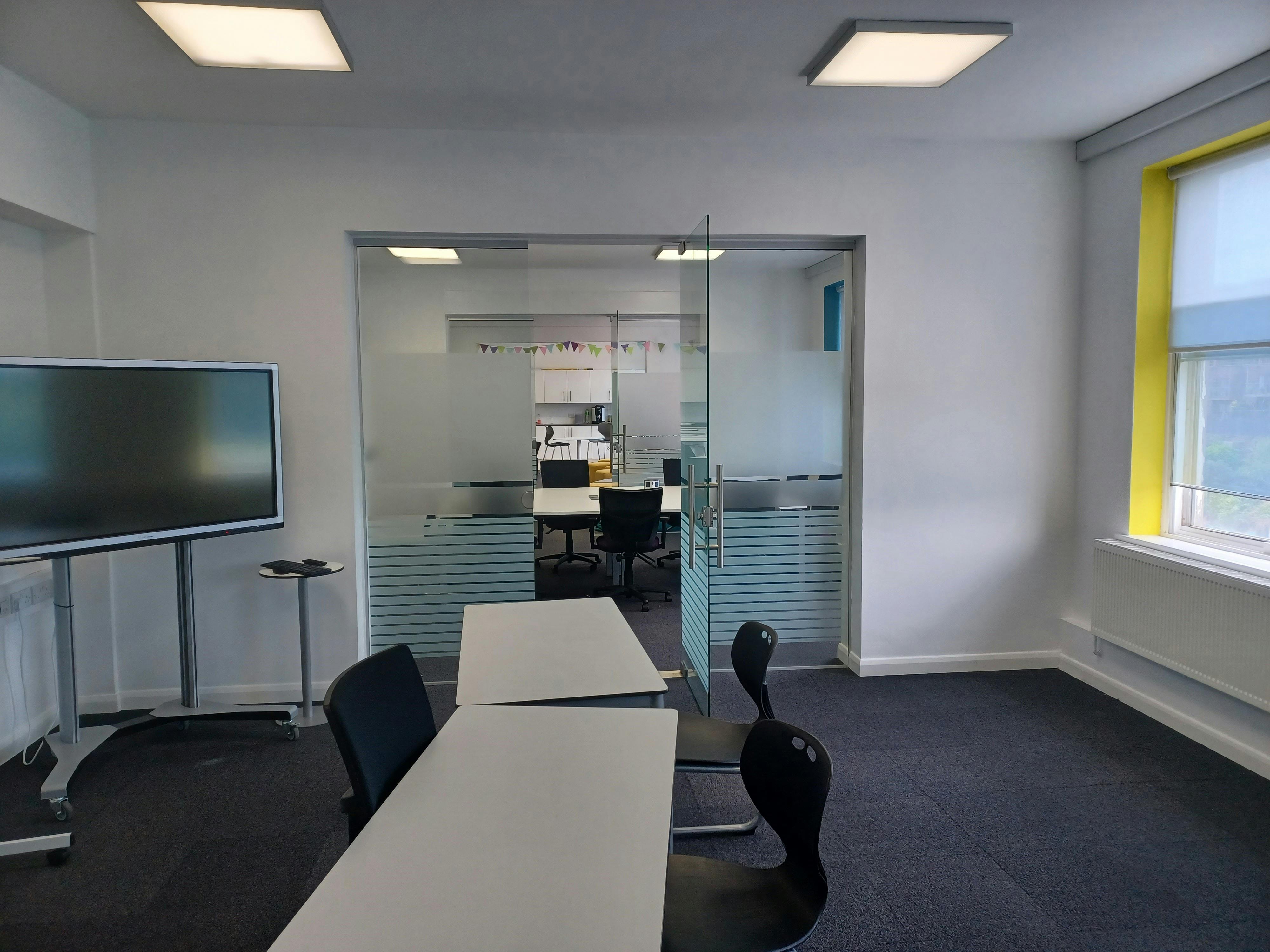 Modern glass-walled meeting space at BSC Brighton for collaborative workshops and presentations.