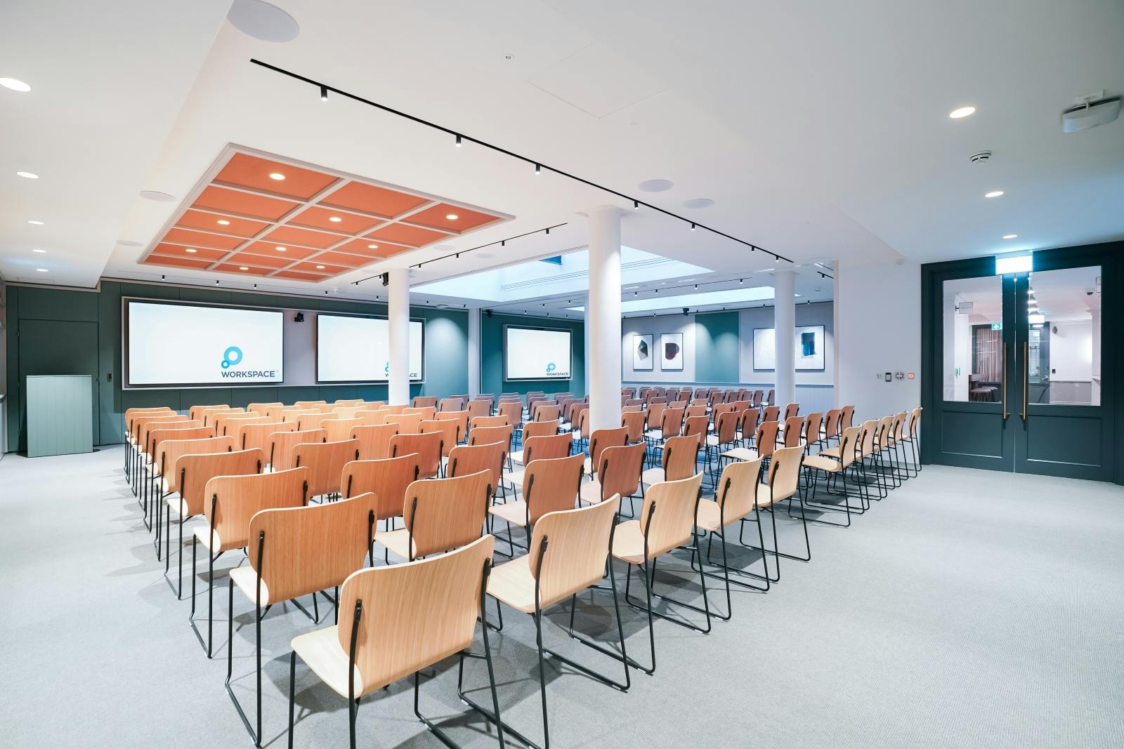 Conference room setup with wooden chairs and screens at Salisbury House event.