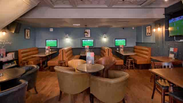 Cozy venue with comfortable seating for informal meetings and sports events.