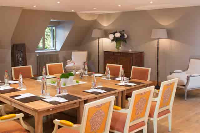 Intimate meeting room at La Ferme saint Siméon with wooden table, ideal for workshops.
