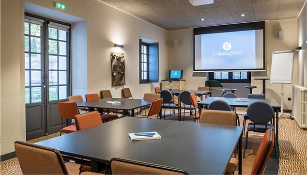 Meeting room at Château de Herces with large screen, ideal for corporate events and workshops.