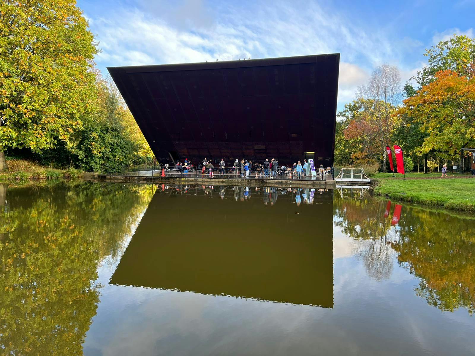 Crystal Palace Concert Platform pavilion reflecting in pond, ideal for outdoor events.