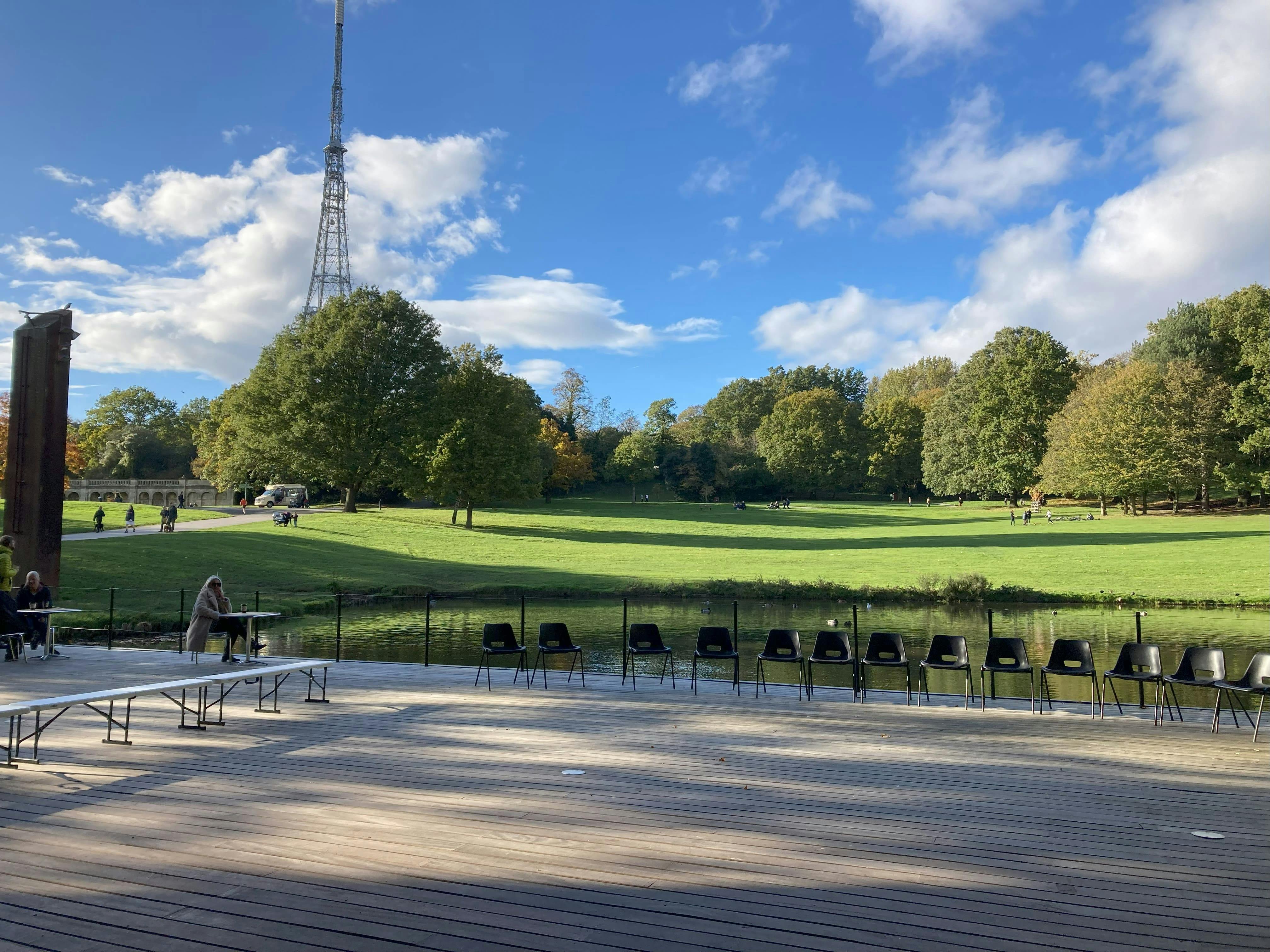 Crystal Palace Concert Platform, wooden deck venue for outdoor events in serene park setting.