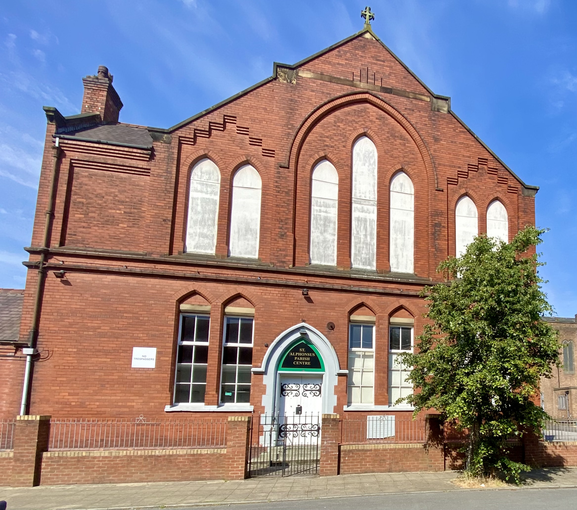 Historic St Alphonsus Parish Centre main room with large windows for events and gatherings. - Banner