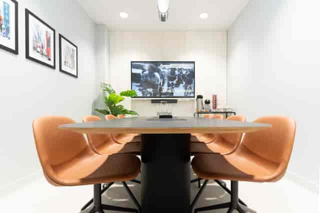 Modern meeting room in The Domane, featuring a sleek table and wall-mounted screen.