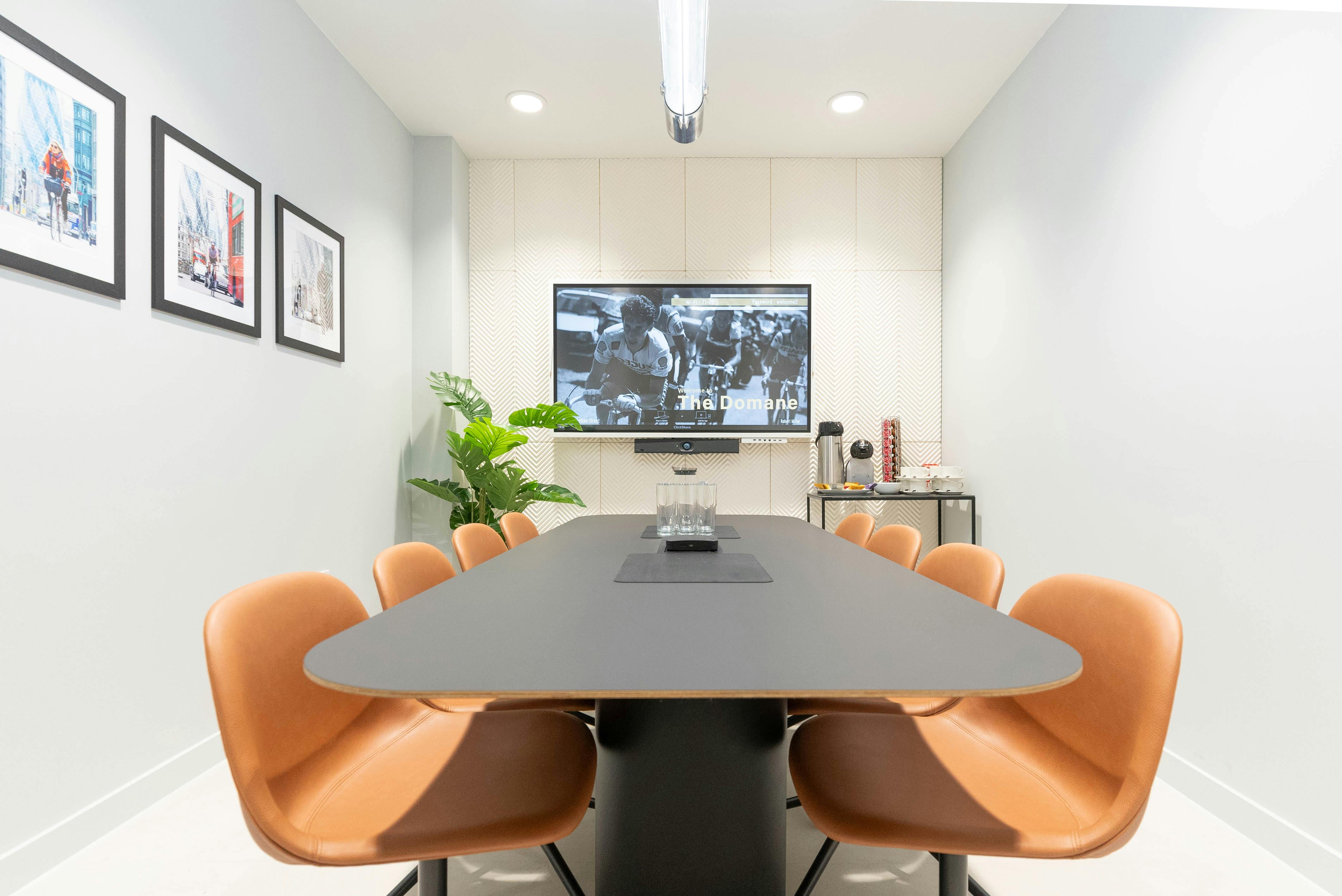 Modern meeting room with sleek black table, ideal for collaboration and presentations.