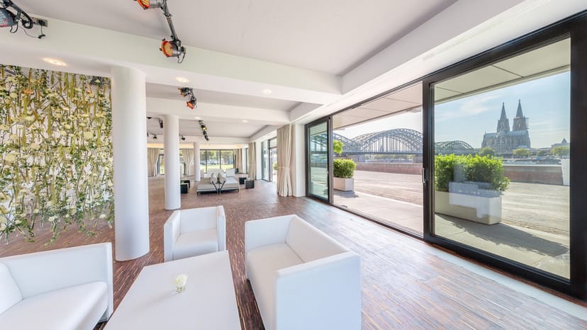 Modern event space in The View Cologne with large windows, ideal for meetings and gatherings.