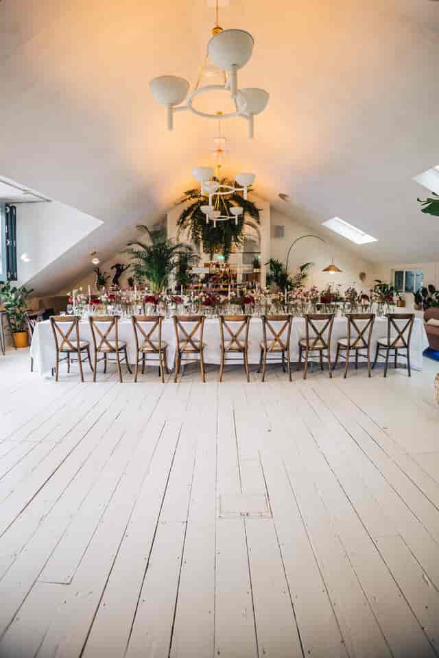 Elegant dining table with floral centerpieces in The Loft, ideal for upscale events.