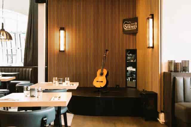 Stylish Strings Restaurant with wooden decor, ideal for live events and private parties.