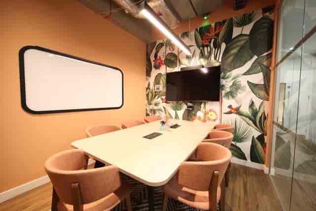 Modern meeting room in Runway East Bloomsbury with tropical wallpaper, ideal for workshops.