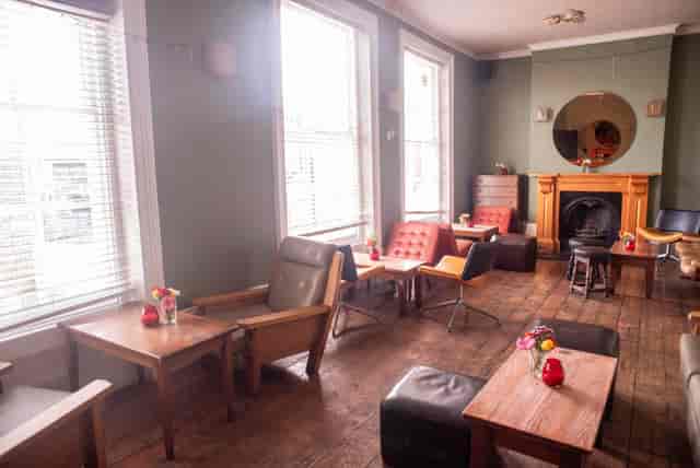 Cozy pub meeting space with natural light, ideal for informal gatherings and brainstorming.