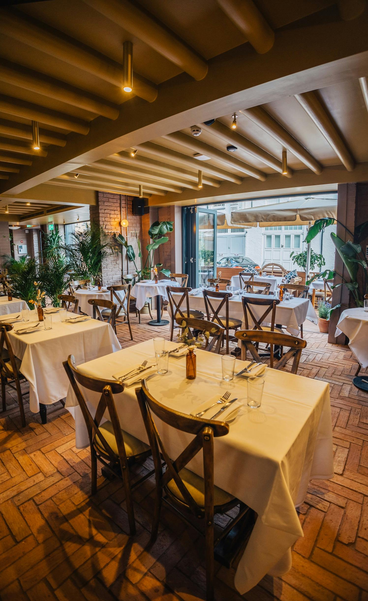 Elegant dining space in LULA with white linens, perfect for corporate events and gatherings.