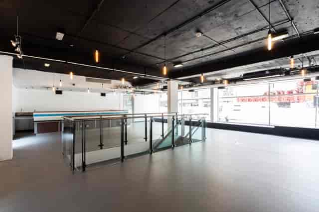 Versatile industrial event space with high ceilings for corporate meetings and social gatherings.