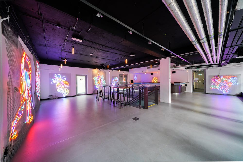 Vibrant event space with neon art, perfect for networking and creative gatherings.