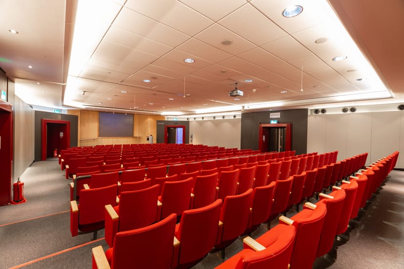 Modern conference room with red seating, perfect for seminars and workshops.