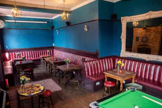 Cozy Function Room at The Chequers with plush red seating for networking events.