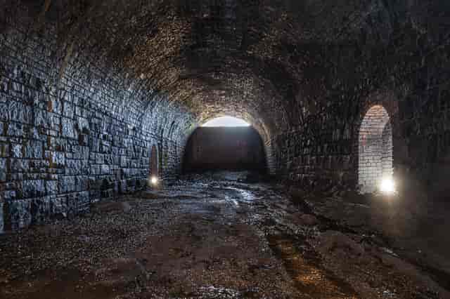 Disused railway tunnel with stone walls, ideal for immersive events and gatherings.