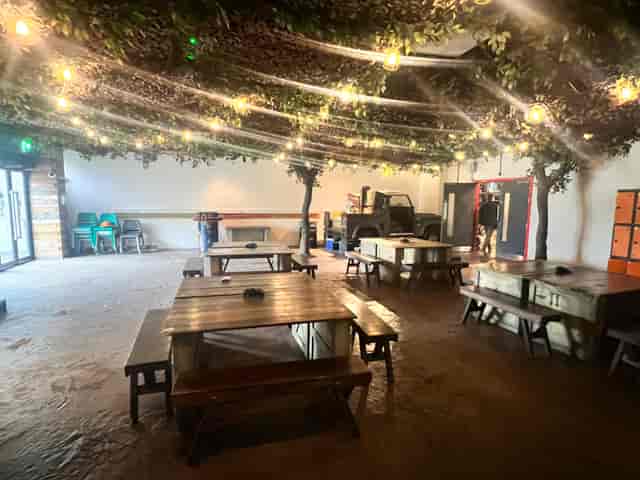 Versatile event space with rustic tables, ideal for gatherings and meetings at Bear Grylls Adventure.